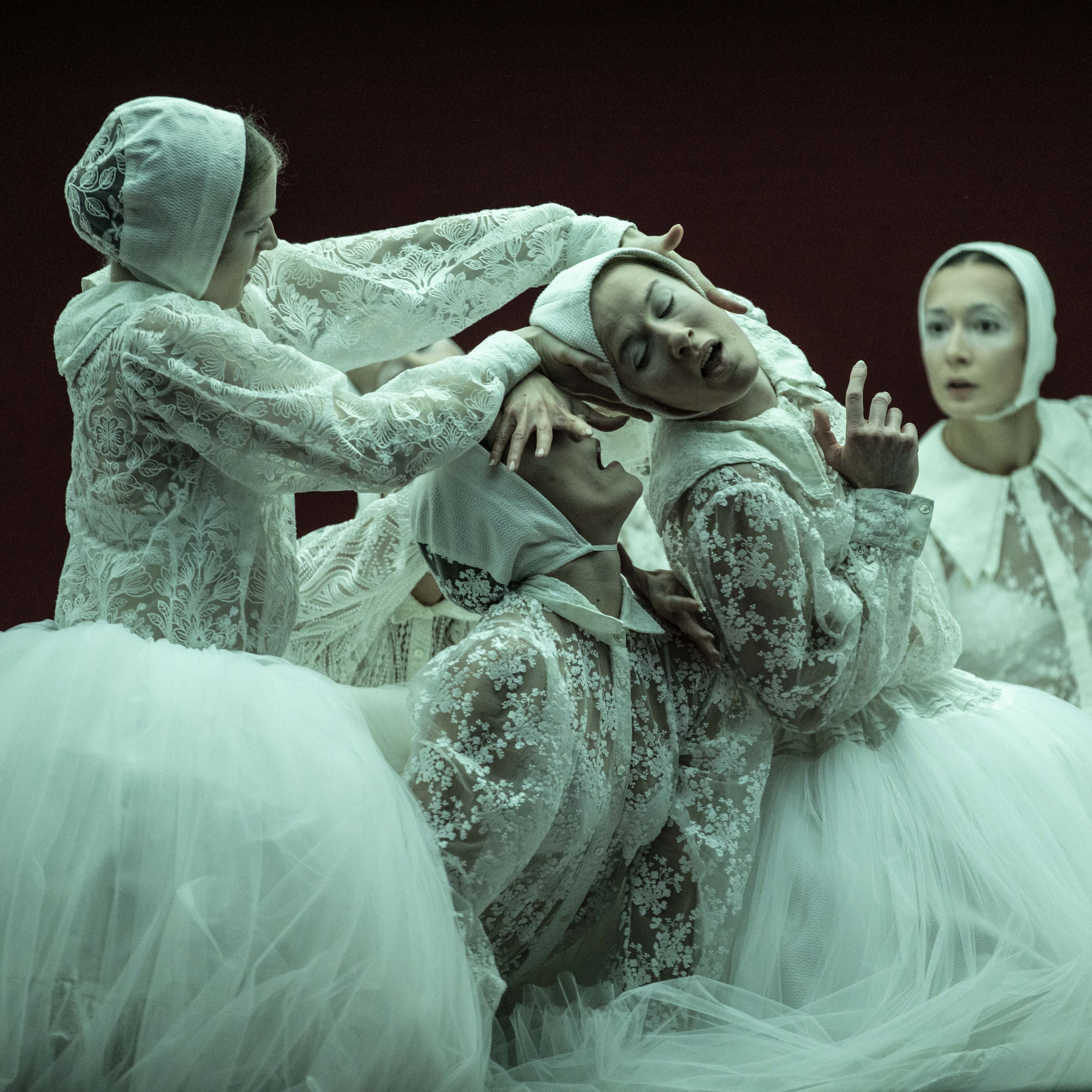 Danseuses vêtues de tutus et de hauts en dentelle blanche penchées les unes sur les autres