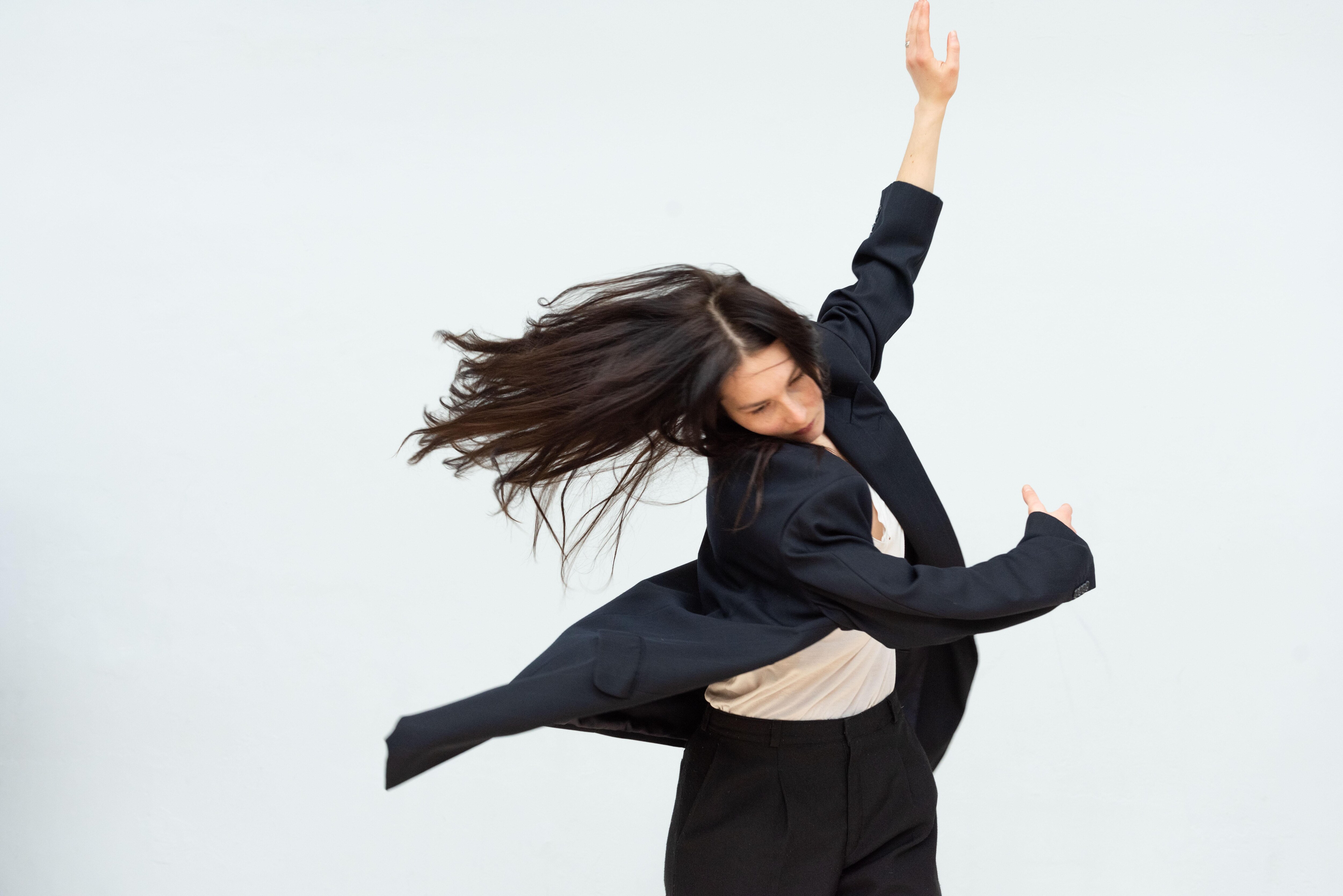 A dancer performing Anne Teresa De Keersmaeker’s Sand/Encore 1Été, her arms in movement to her side