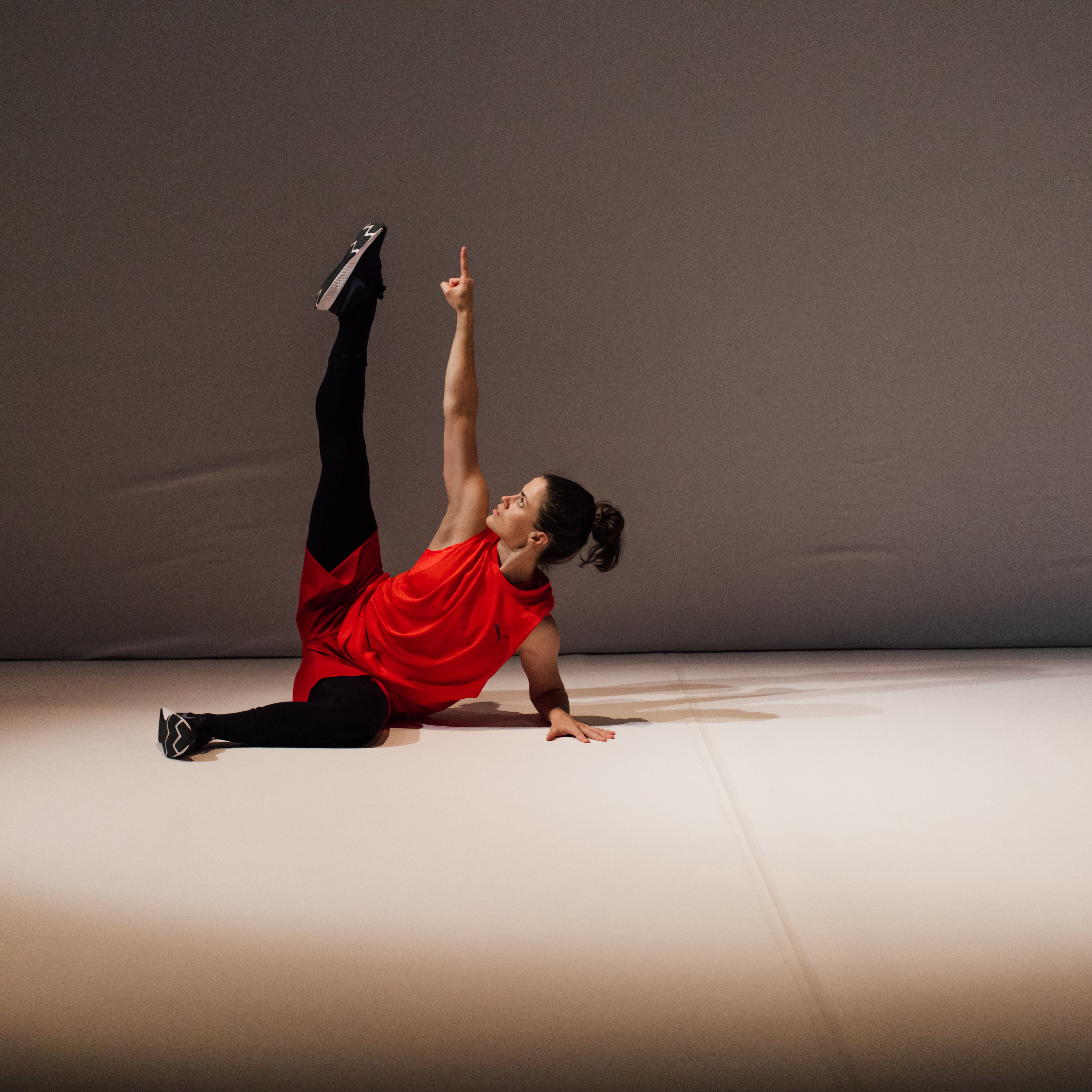 Danseuse semi-couchée, une jambe et un bras vers le haut