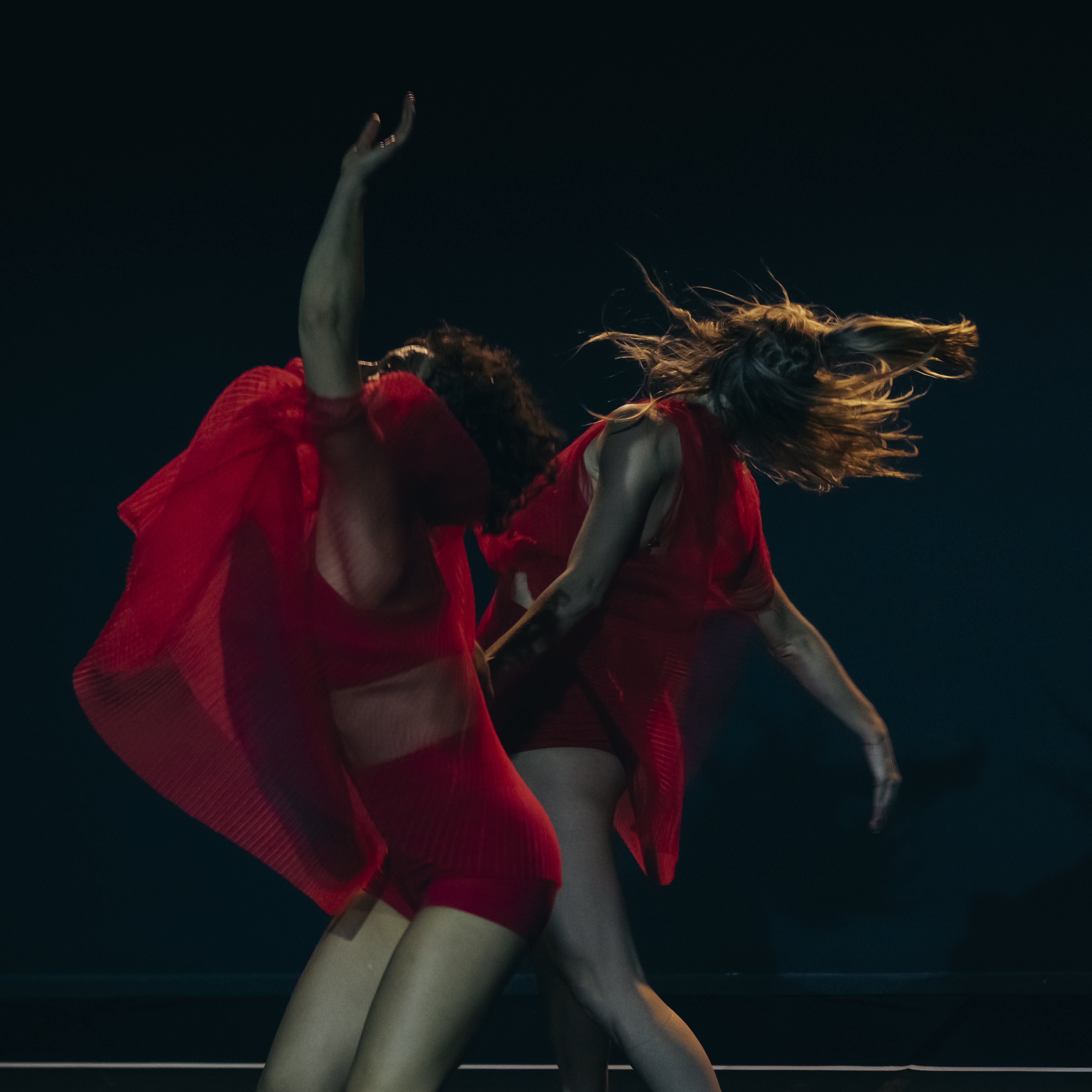 Deux danseuses vêtues de rouge dans How To Be Us de Lucy Guerin